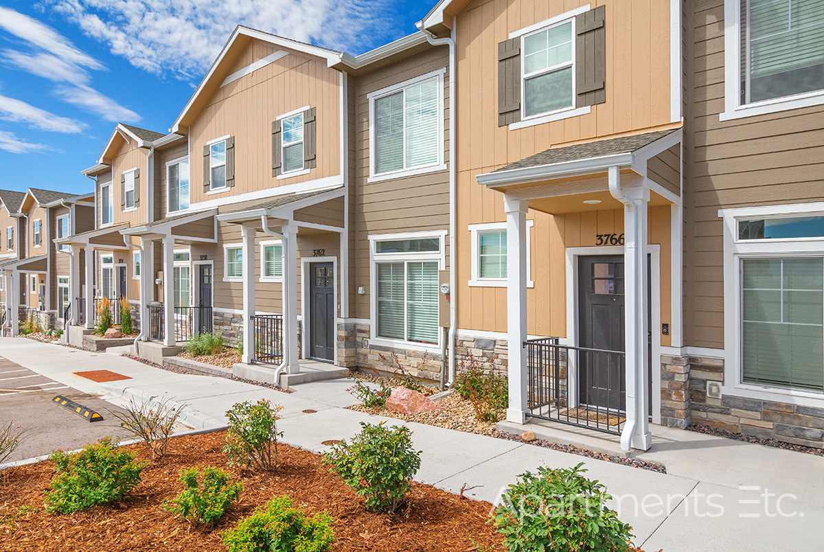 Modern apartment buildings with landscaped walkways in Colorado Springs.