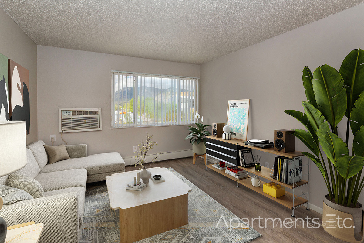Apartment living room with seating area, natural light, and modern flooring.
